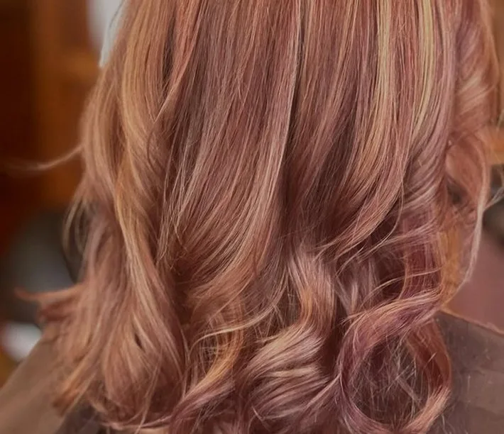 Soft highlighted waves in a rose-gold blonde